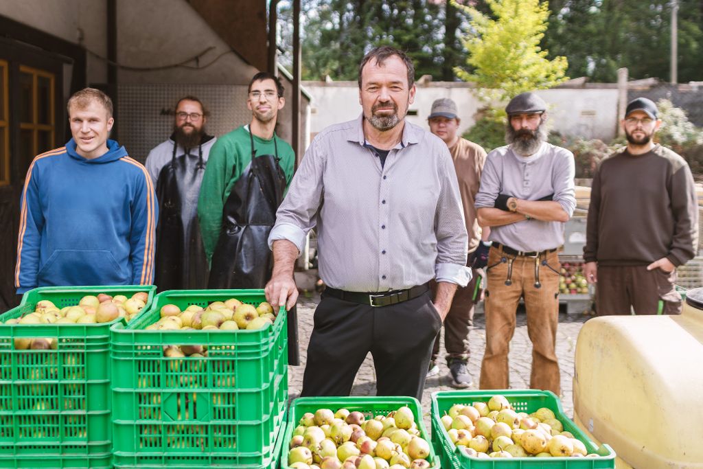 Männer stehen hinter gefüllten Obstkisten