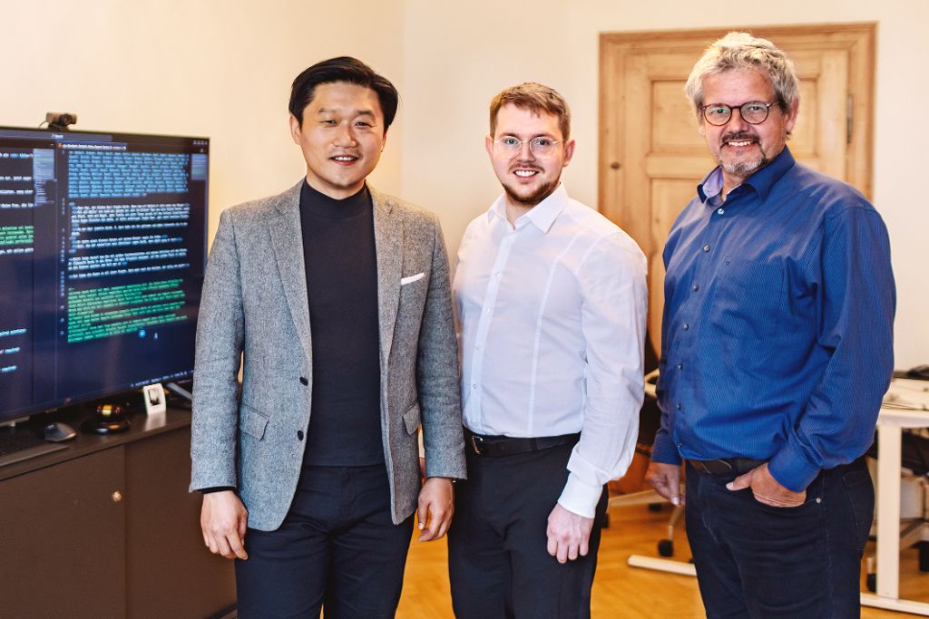 Drei Männer vor Monitor