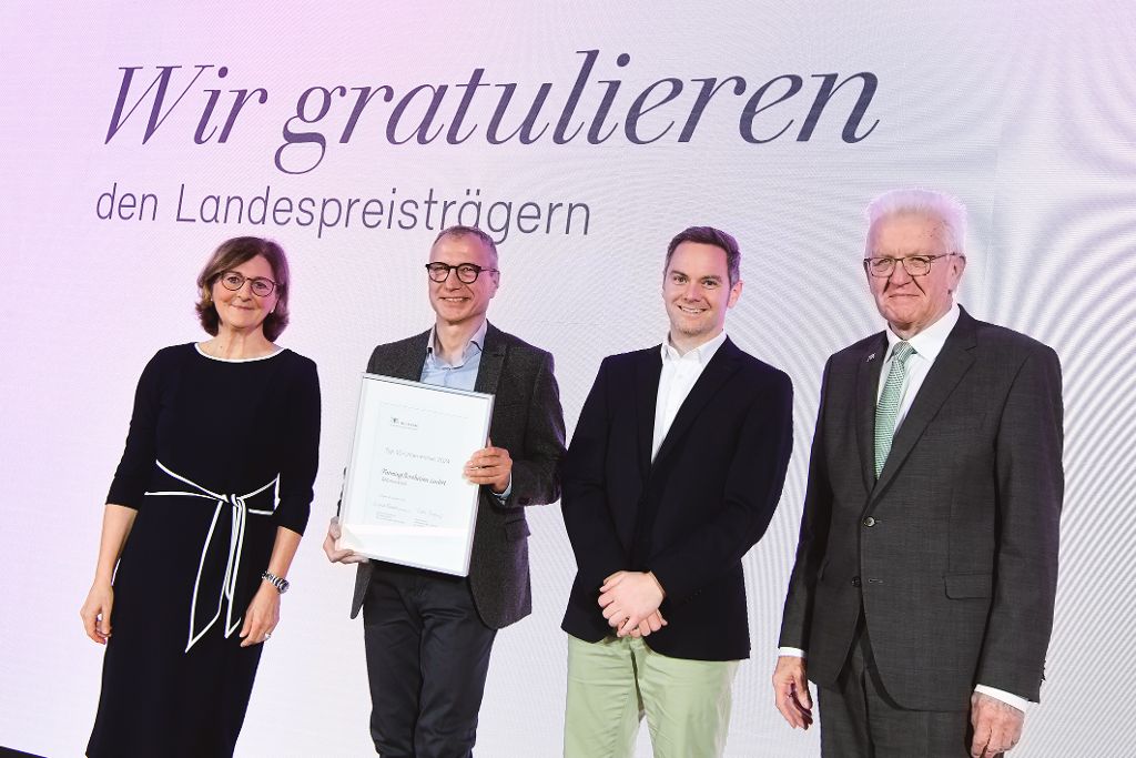 Edith Weymayr und Winfried Kretschmann mit Landespreis-Preisträger auf der Bühne.