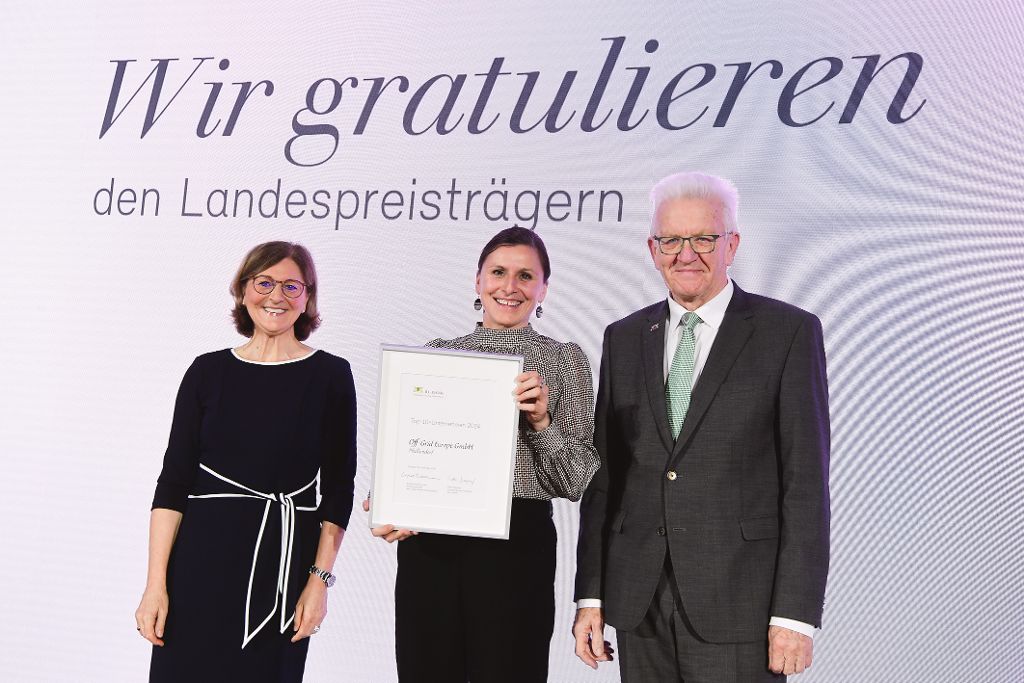 Edith Weymayr und Winfried Kretschmann mit Landespreis-Preisträger auf der Bühne.